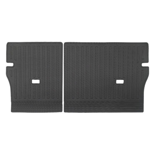 A pair of black rubber car trunk floor mats with a textured, ribbed pattern and cutouts, displayed side-by-side on a white background.