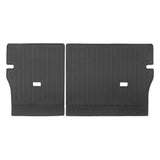 A pair of black rubber car trunk floor mats with a textured, ribbed pattern and cutouts, displayed side-by-side on a white background.
