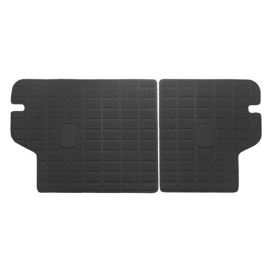 A pair of black rubber car trunk floor mats with a textured grid pattern and cutouts, displayed on a solid white background.