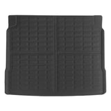 A black rubber car trunk liner with a grid-like textured pattern, shown flat against a white background.